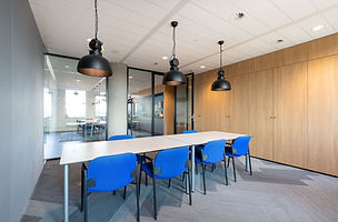 Clean commercial conference room with long table and blue chairs