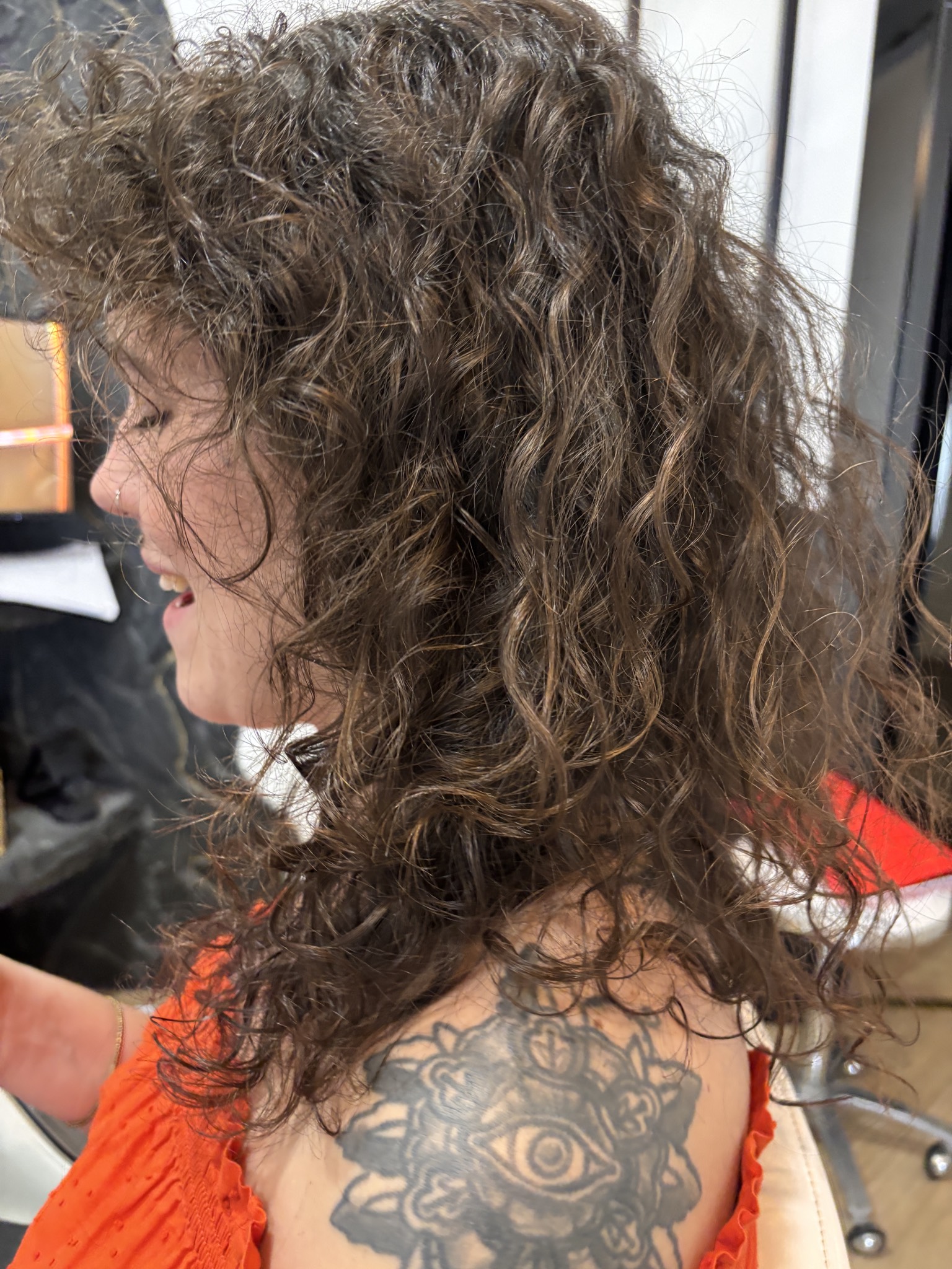 Cliente souriante, cheveux bouclés