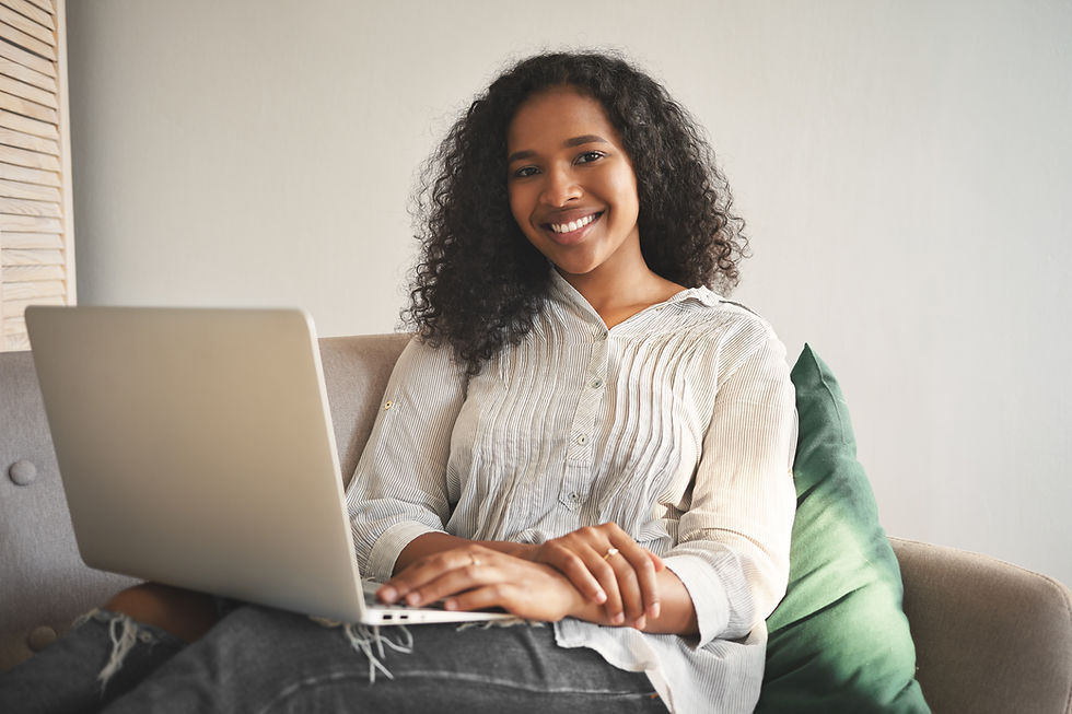 portrait-cheerful-young-african-woman-jeans-shirt-smiling-broadly-while-surfing-internet-g