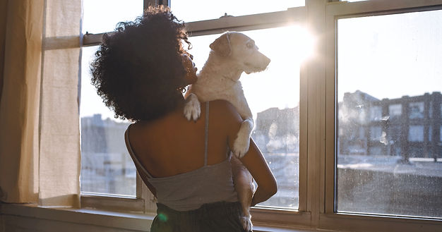 En kvinna som lyft upp sin hund för en kram