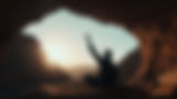 silhouette-person-greeting-sunrise-from-inside-cave-overlooking-mountainous-landscape-earl