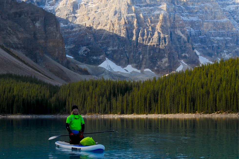 A woman paddle boarding on Moraine Lake Alberta
