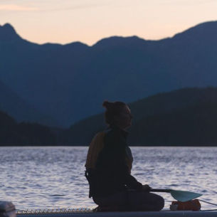 A paddle boarder at sunset in British Columbia Canada
