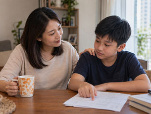 Mother reassuring her son while reviewing schoolwork at home