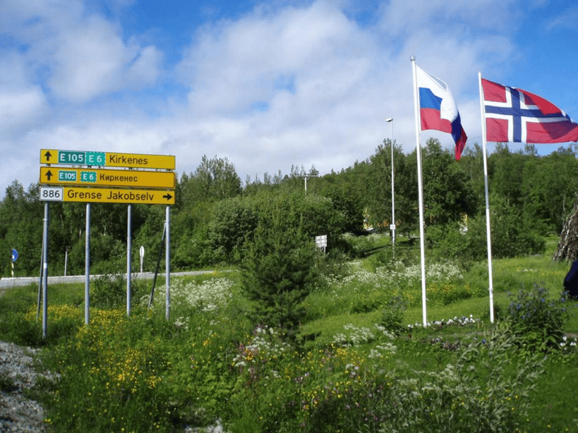 2 drapeaux (russe et Noevegien) flottant au vent. des Panneaux de signalisation.