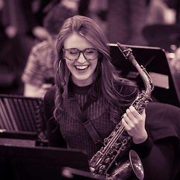 Melinda, online vocal and songwriting coach at Inspired Playing, singing and playing piano during a concert performance.