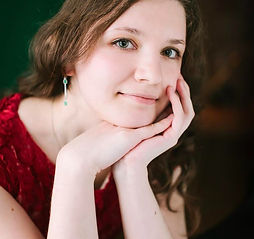 Melinda, online vocal and songwriting coach at Inspired Playing, singing and playing piano during a concert performance.