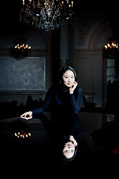 Melinda, online vocal and songwriting coach at Inspired Playing, singing and playing piano during a concert performance.