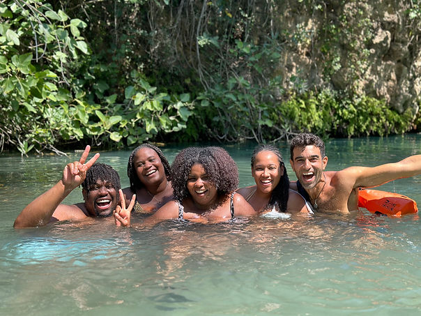 a group of young men and women having fun in a lake during a day water tour