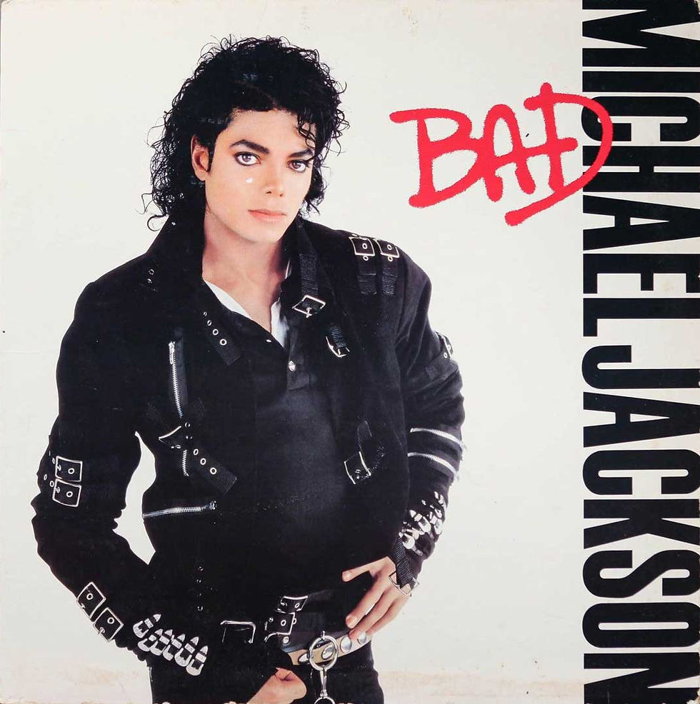 Michael Jackson in black leather jacket on a white Bad album cover, with red Bad text and vertical MICHAEL JACKSON lettering.