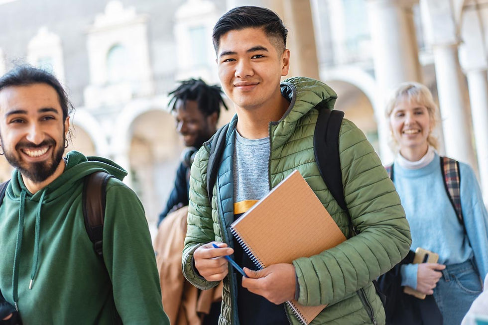 Smiling diverse students with backpacks walk outdoors under arches; one holds a notebook and pen, suggesting a cheerful campus scene.