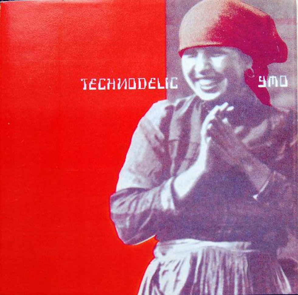 Smiling woman in a headscarf claps against a red background with TECHNODELIC text and small ymo lettering.