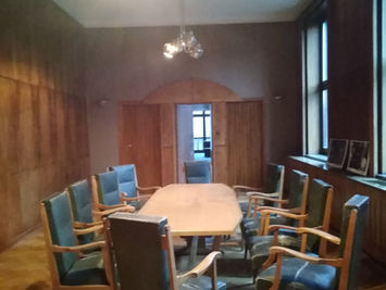 Sala de reunions històrica a Nowa Huta amb cadires de fusta.