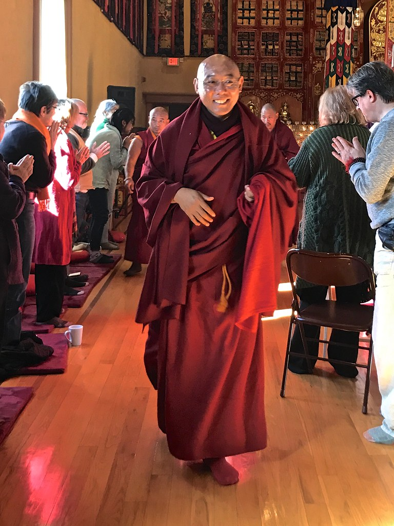 Tibetan monk wrapped in a maroon robe.
