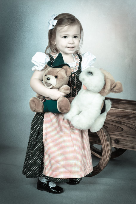 Kleines Mädchen im Dirndl mit Teddybär – Bambina in dirndl con orsacchiotto