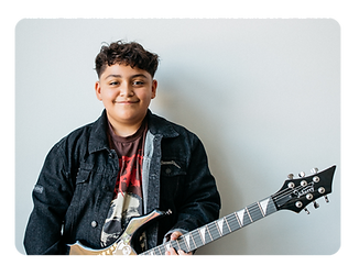 Kids guitar student smiling during a guitar lesson