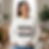 Woman smiles in white 'MAIN CHARACTER MOM' sweatshirt