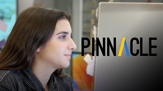 Pinnacle editor in chief, Maya, is looking at a computer screen. The Pinnacle logo is in front of her.