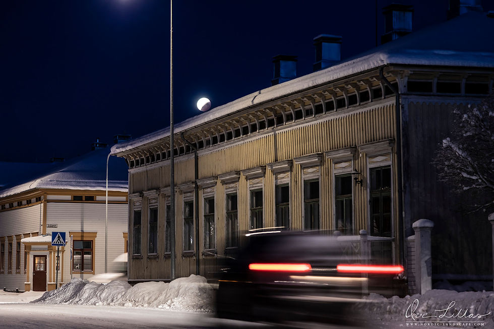 Lunar eclipse over small town.