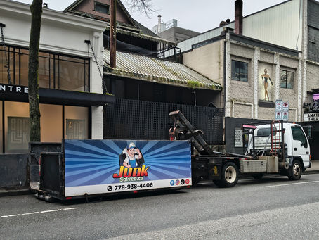 An eye-level view of a Junk Solved rubbish removal truck parked outside of a Metro Vancouver property, prepared for service.