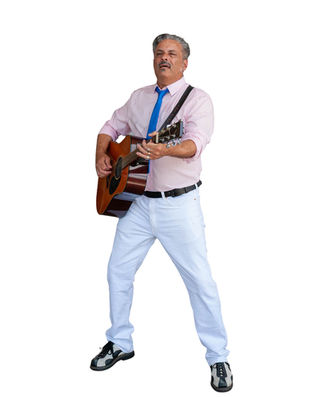 Incredibly handsome man playing acoustic guitar. He's wearing a pink shirt, blue tie, white pants and black and white two-tone shoes