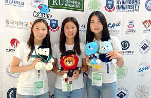 Three women holding plush toys at a 2024 event