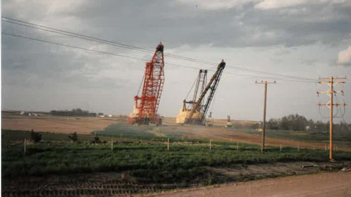 Two industrial cranes in a field