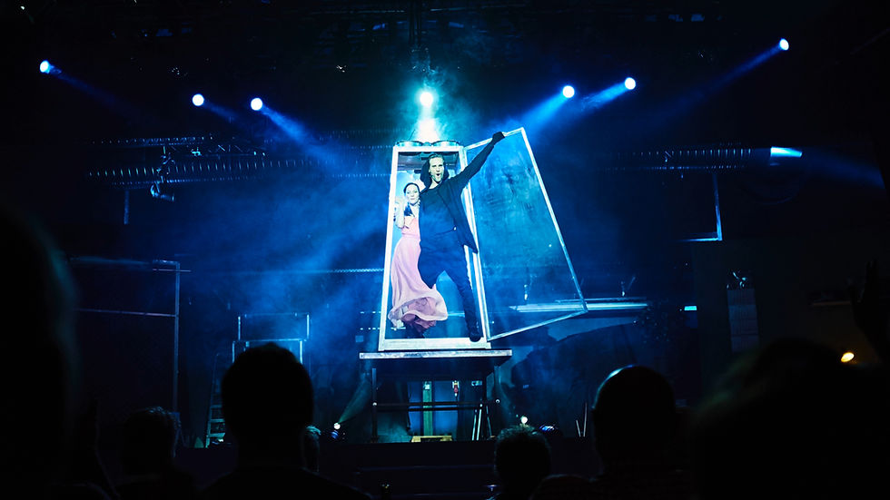 Julius Frack performing a large-scale illusion on a theatre stage
