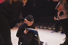 Stage manager Steff kneeling with a script, handling stage management duties