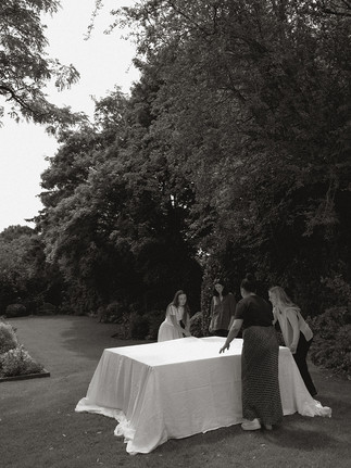 Wedding suppliers draping a table outdoors 