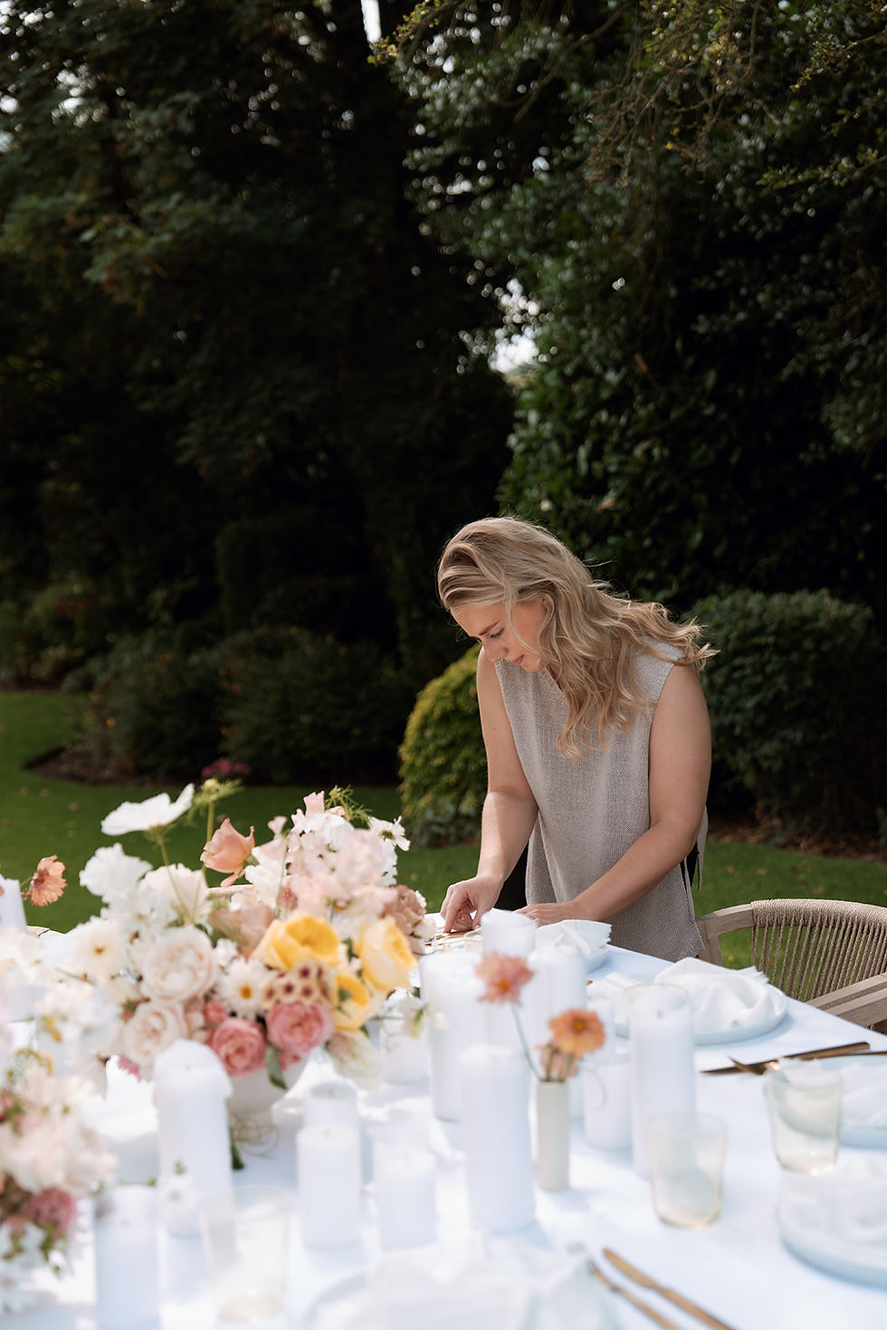 A wedding supplier making final touches to wedding breakfast table