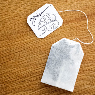Etiquette Grow avec le dessin d'une plante monstera accroché à un sachet de thé