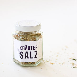 Kleines Schraubglas mit weissem Deckel. Auf dem runden Deckel ist die gelbe Illustration einer Zitrone zu sehen. Weisse Etikette mit dem Text: Kräuter Salz