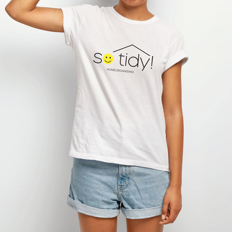 Femme avec un t-shirt blanc et le logo so-tidy! homeorganising imprimé dessus en noir et jaune (smiley) la femme porte un short en jeans court.