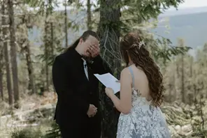 bride and groom read private vows in the woods