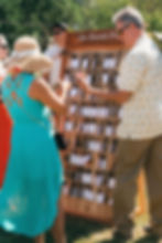 Color photo of wedding guests finding their luggage tag escort cards
