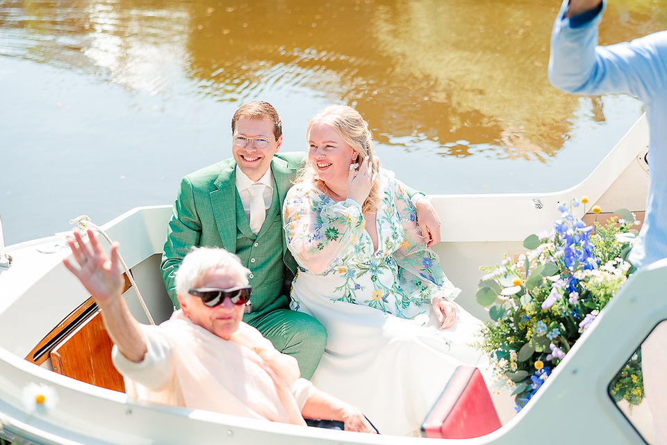 bruidspaar zit samen met oma in de boot