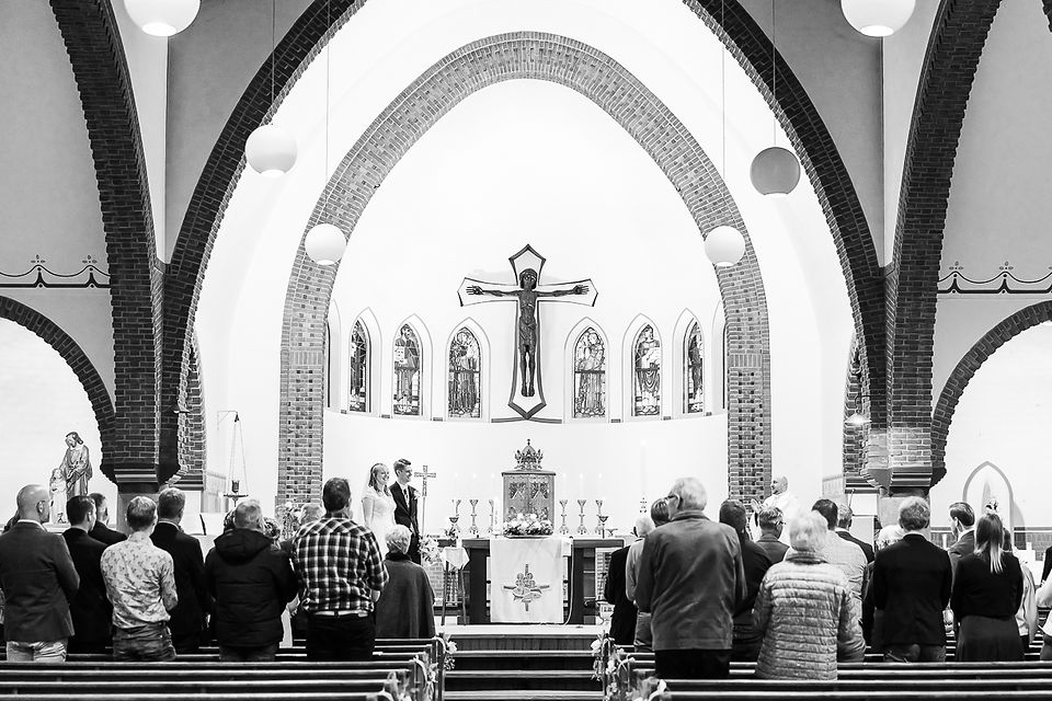 Overzicht van altaar met gasten in gebedsmoment in sfeervolle kerk