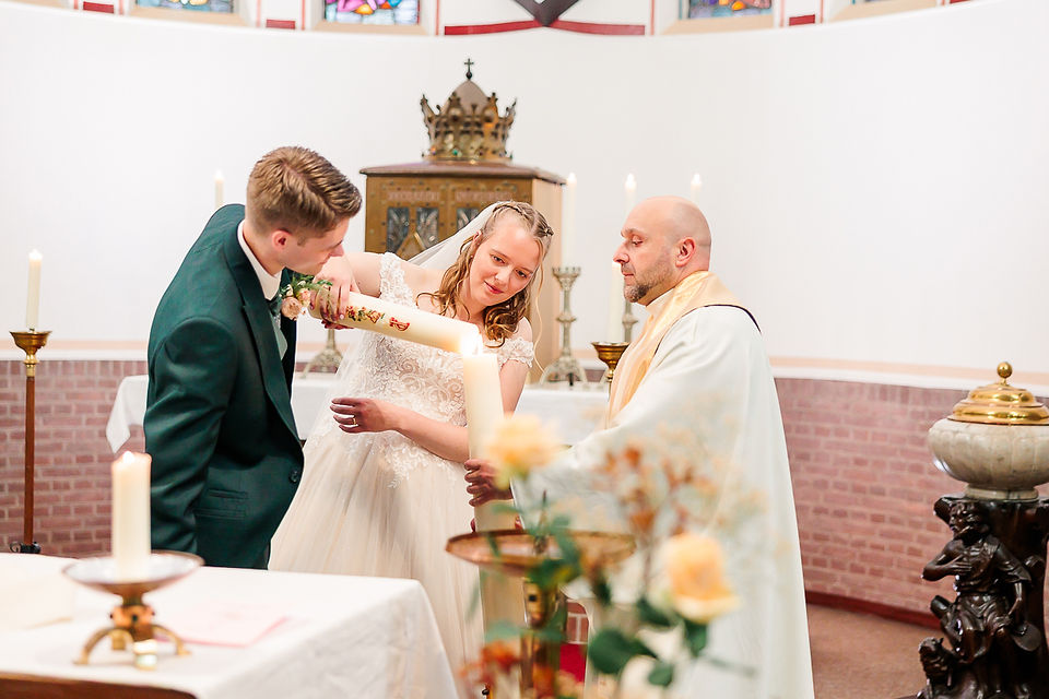 Bruid en bruidegom steken samen kaars aan tijdens symbolisch ritueel