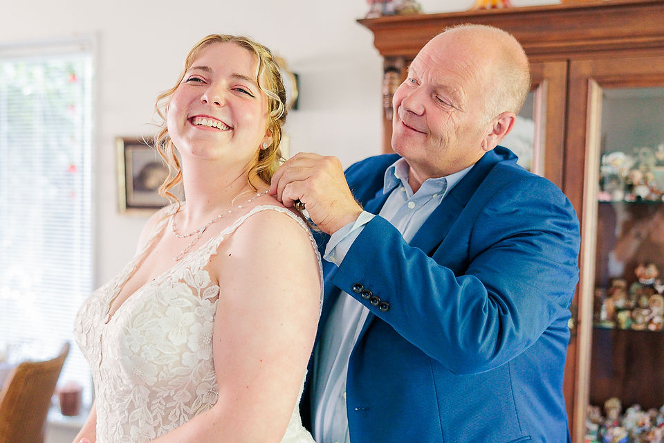 Vader van de bruid doet de ketting om bij zijn dochter