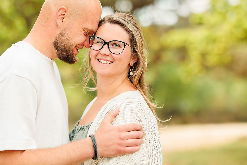 Loveshoot van een stel in een groene, rustige omgeving, ontspannen moment samen in natuurlijk licht.