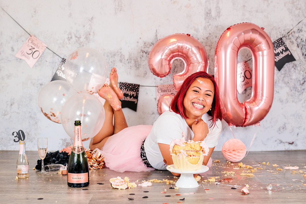 lachende vrouw met giant cupcake cijferballonnen en champagne