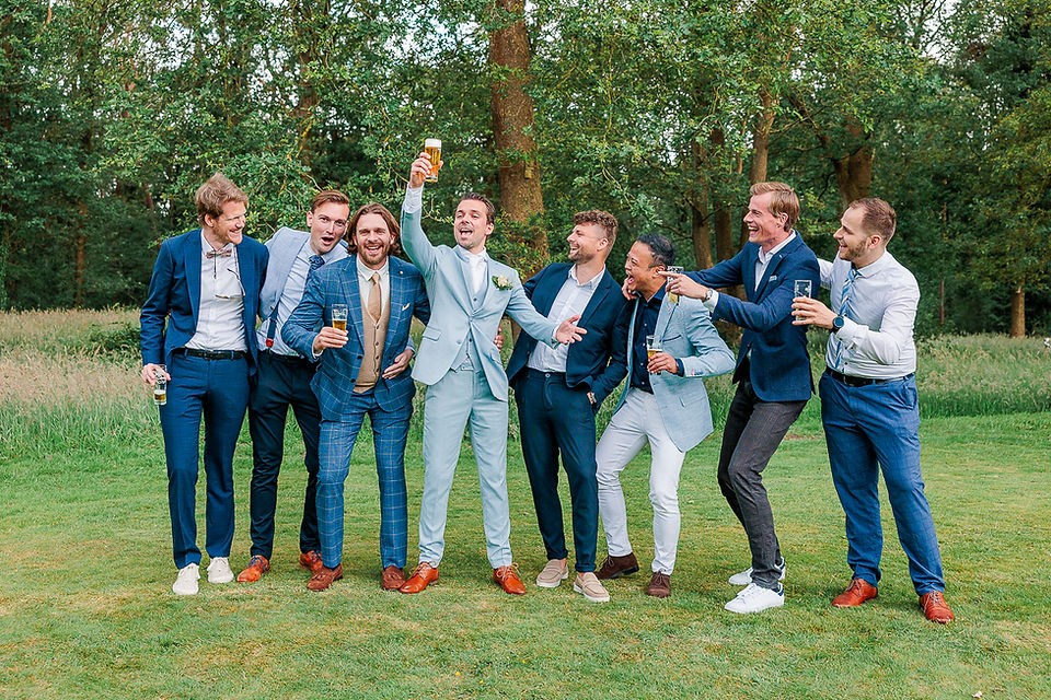 Bruidegom proost met zijn vrienden tijdens de groepsfoto's