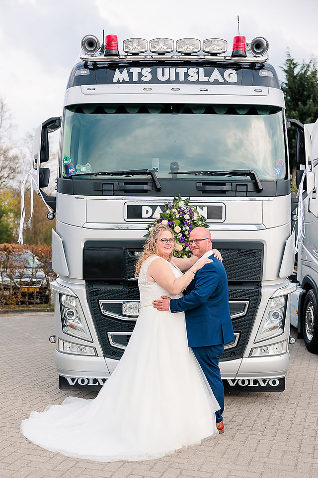 Bruidspaar poseert voor trouwauto