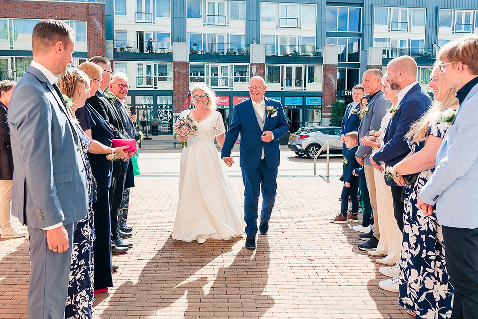 Bruid en bruidegom worden feestelijk onthaalt door hun gasten