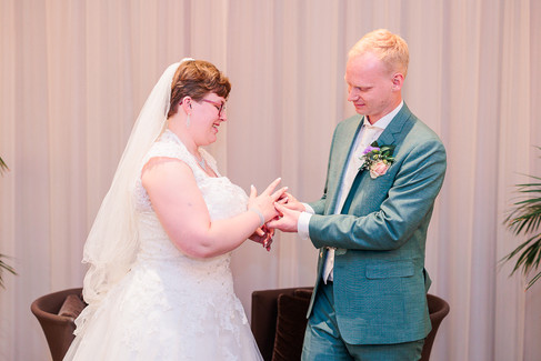 bruidegom schuift de trouwring om de ring van zijn vrouw