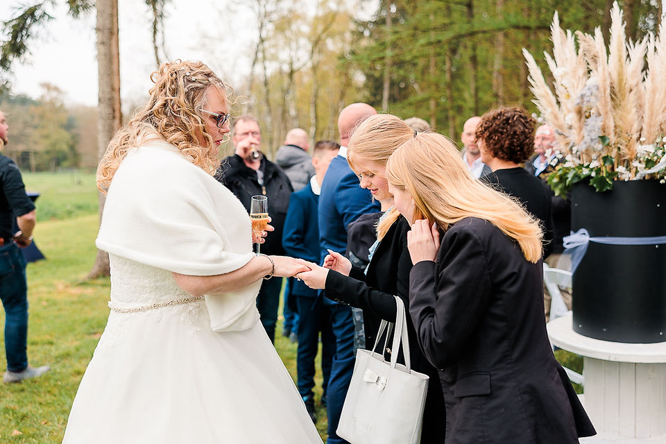 bruid toont trouwring aan bruidsmeisjes