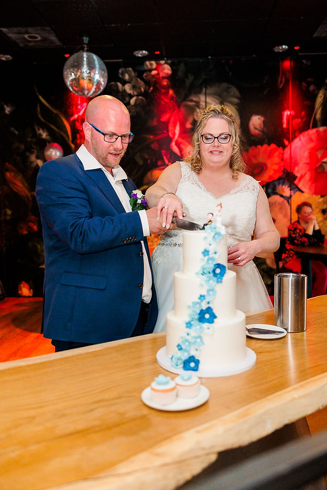 Bruidspaar snijdt samen de bruidstaart aan