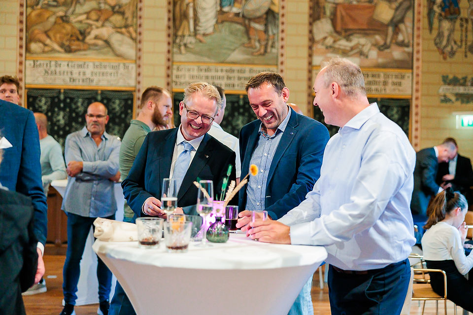 mannen lachen aan een statafel