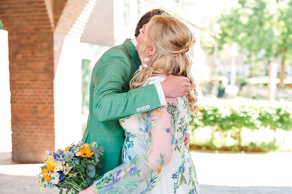liefdevolle omhelzing tussen bruidspaar